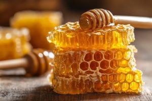 Fresh honeycomb drizzled with honey on rustic wooden table